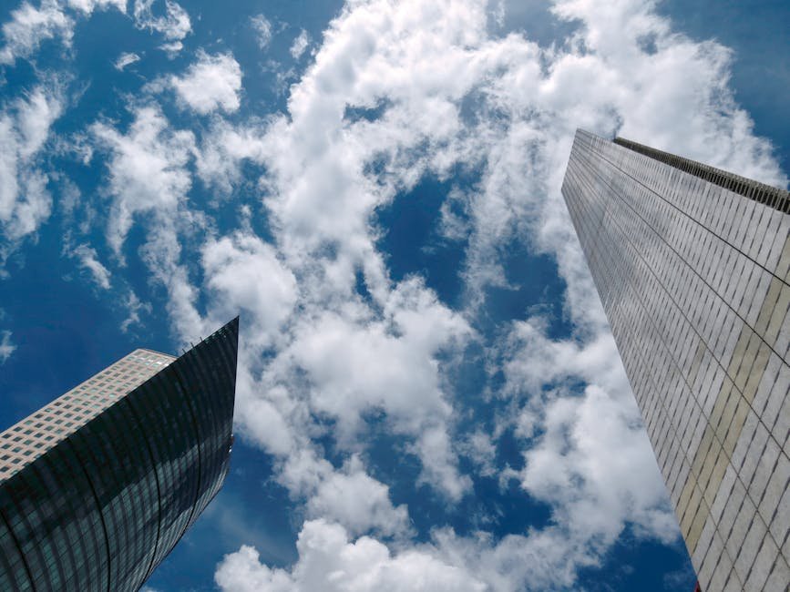 View of Mexico City skyscrapers reaching into a cloud-strewn blue sky.
